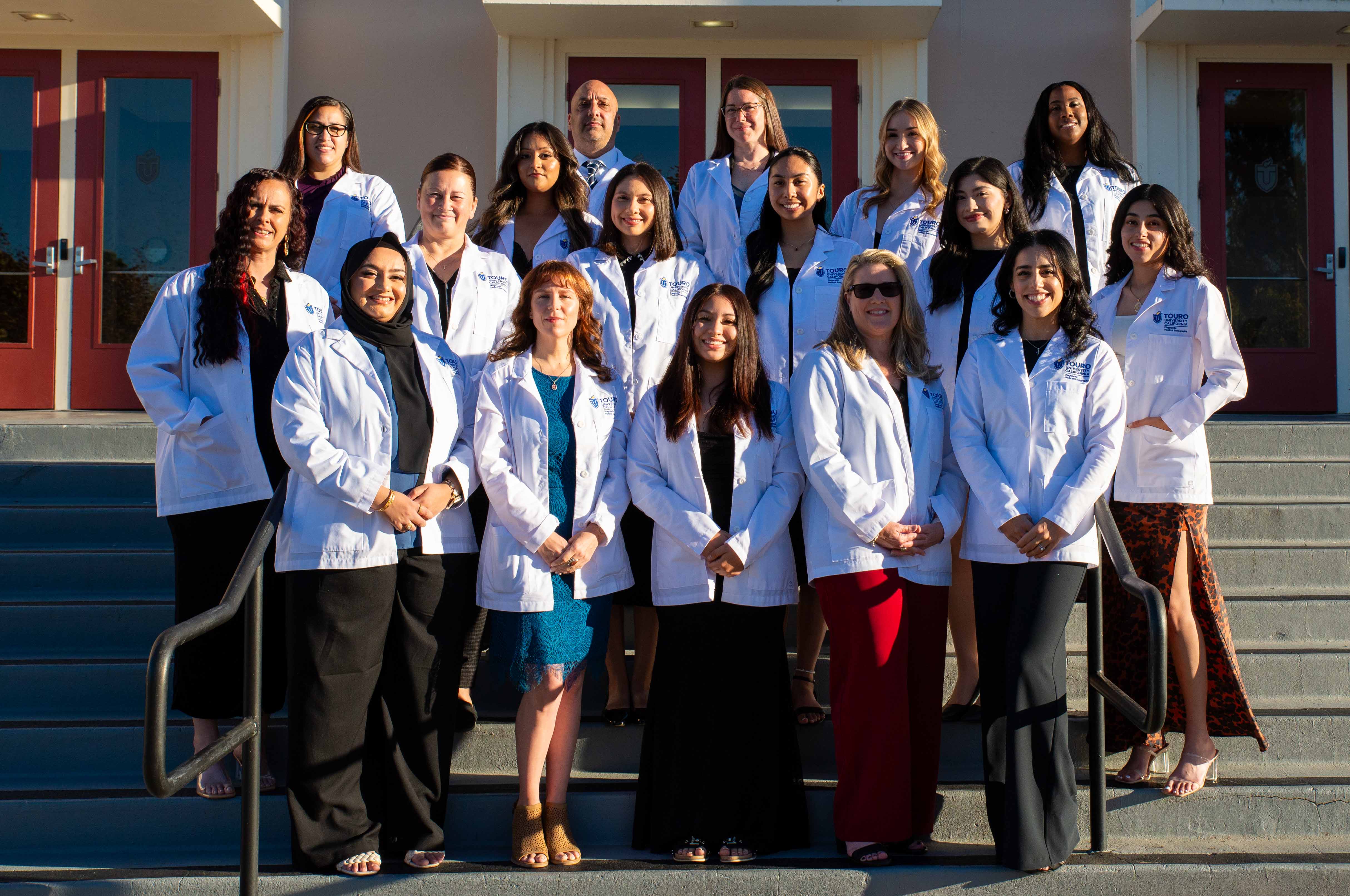 Students from the Diagnostic Medical Sonography Class of 2026 pose in front of Lander Hall in their newly donned white coats.