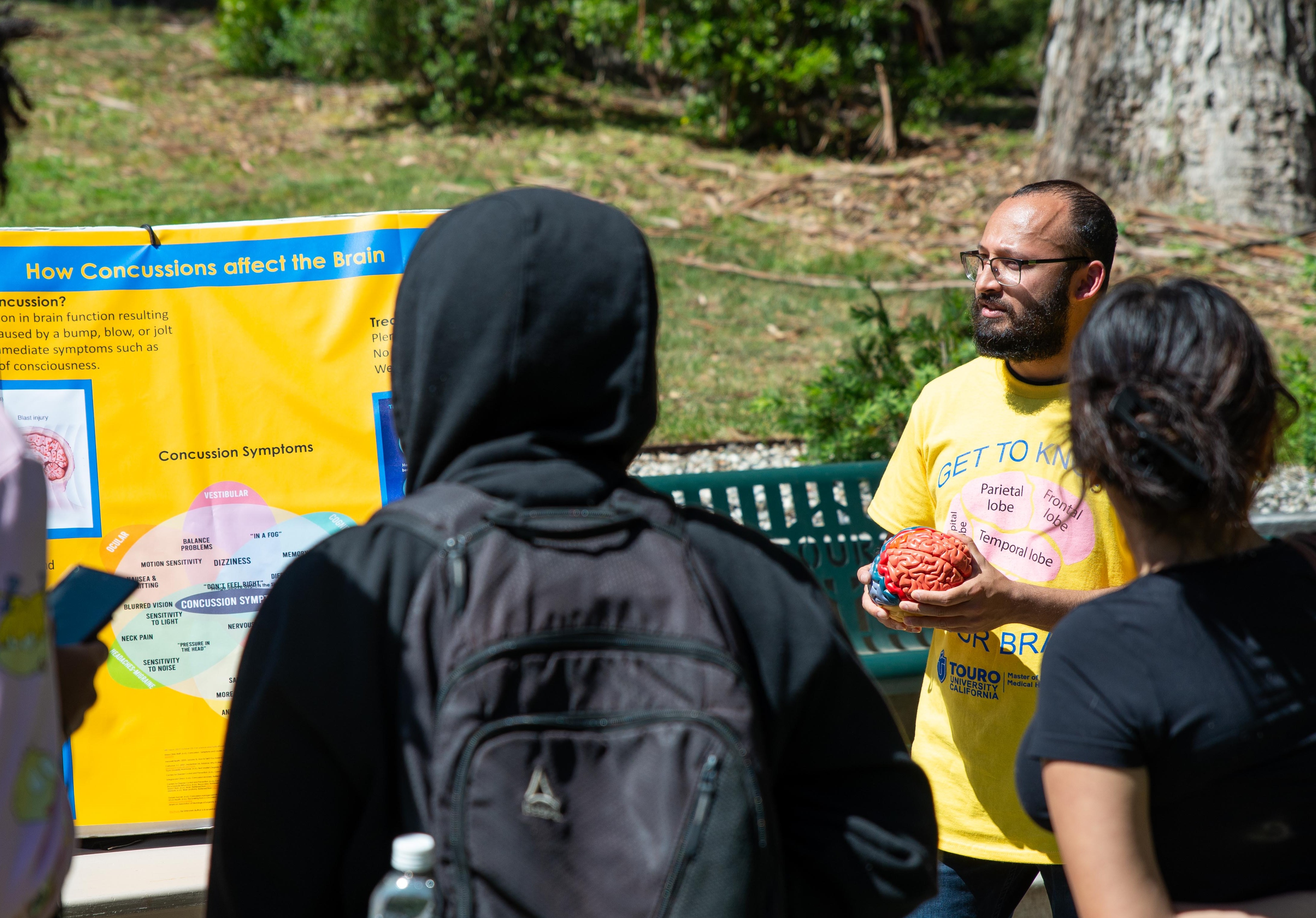 Master of Science in Medical Health Sciences student Danny Lal explains to high school students the effects of concussion using a series of interactive activities.