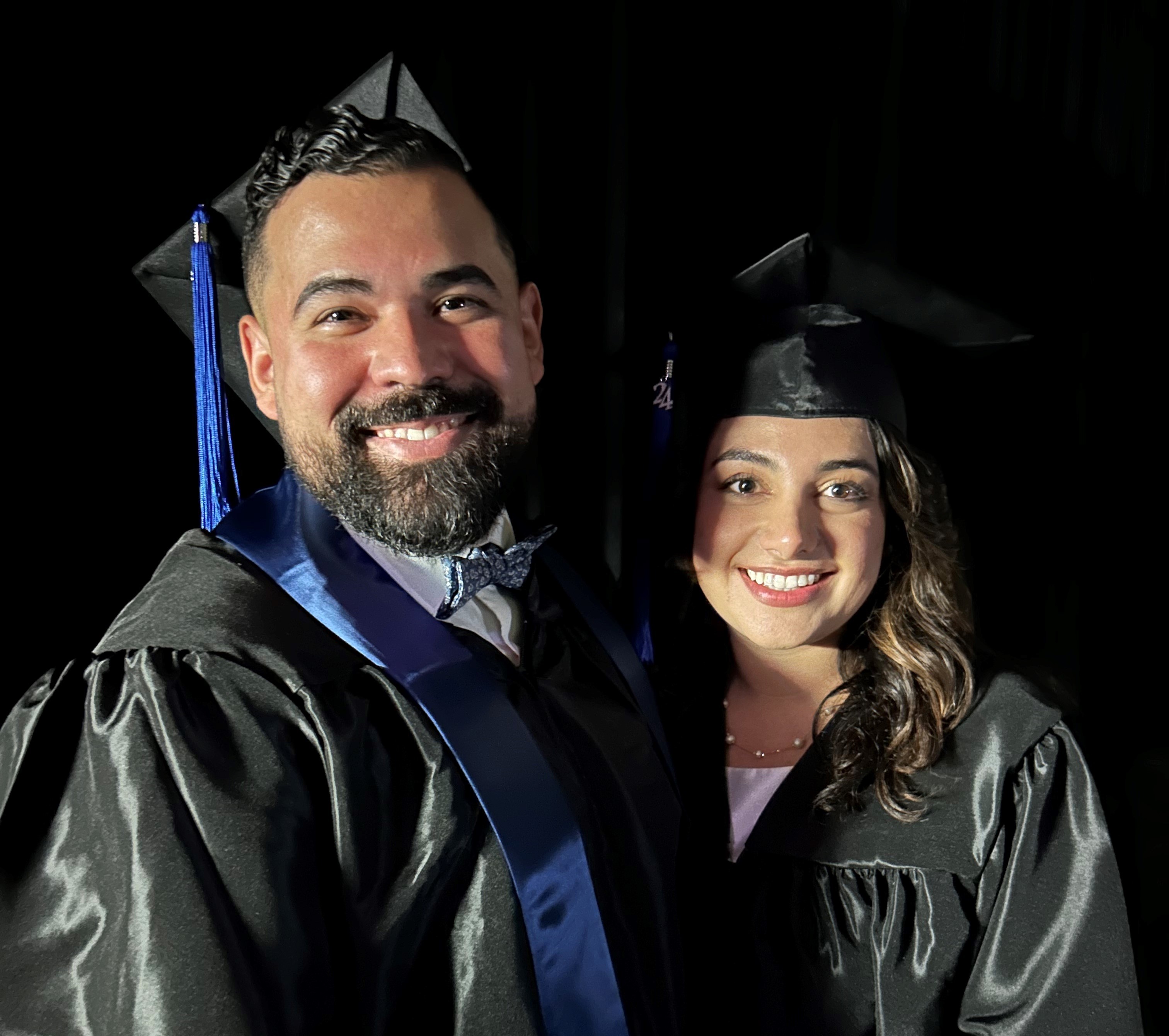 left to right: Kenny Montealegre, Yasameen Sadati wearing graduation robes and caps