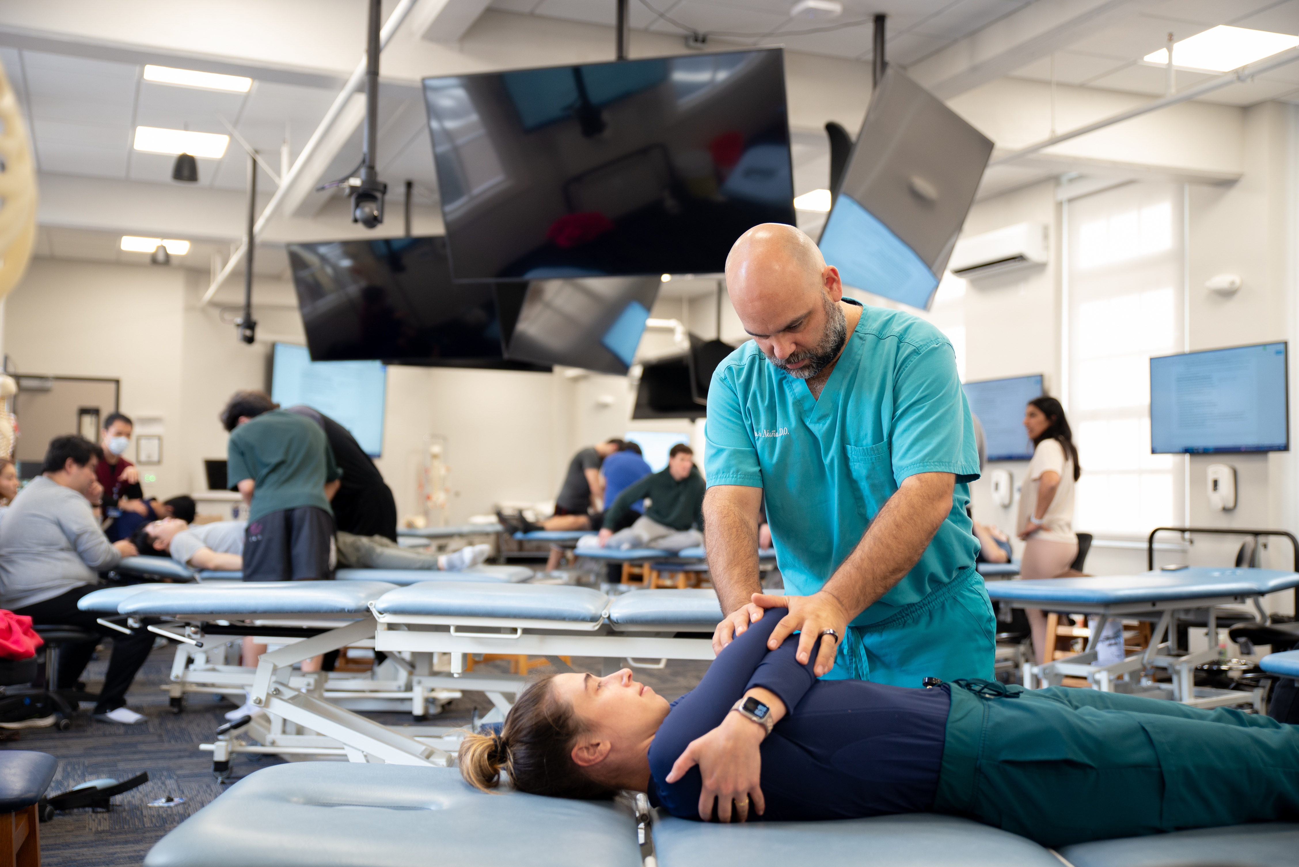 A photo shows Dr. Victor Nu&ntilde;o of Touro University California conducting an osteopathic manipulative medicine workshop.