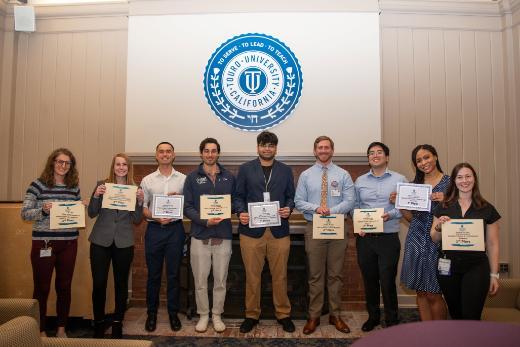 Winners of Research Day contest stand in front of the TUC seal with their certificates