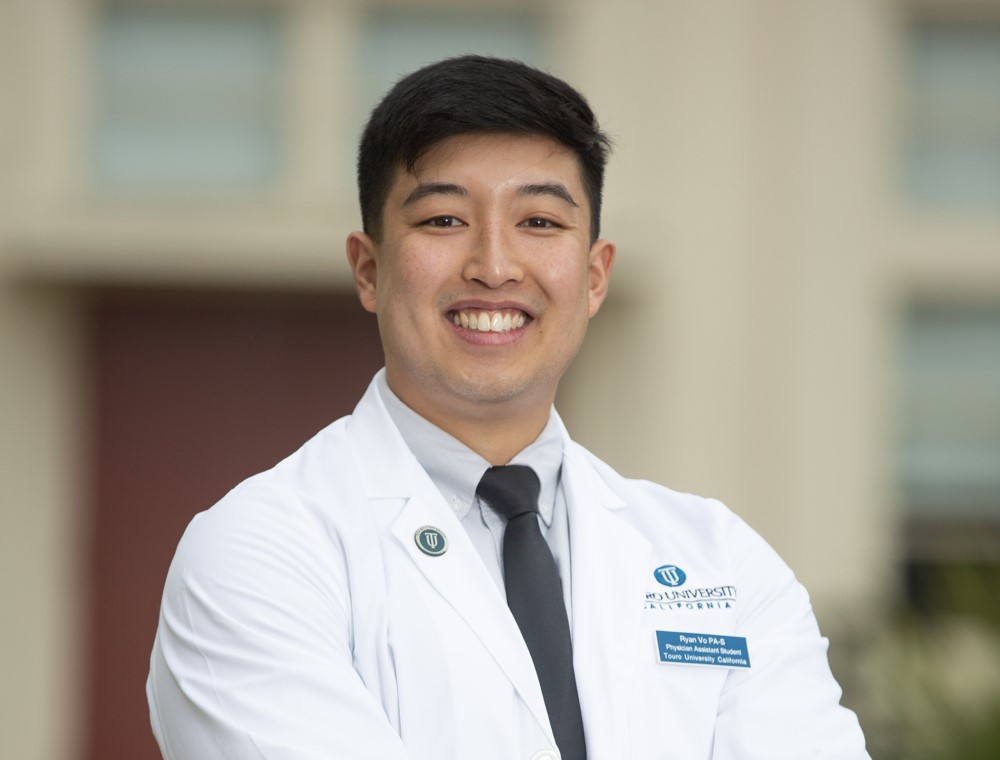 Student in white coat smiling