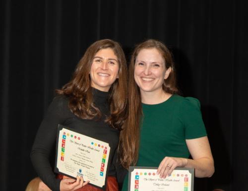 Students stand holding certificates