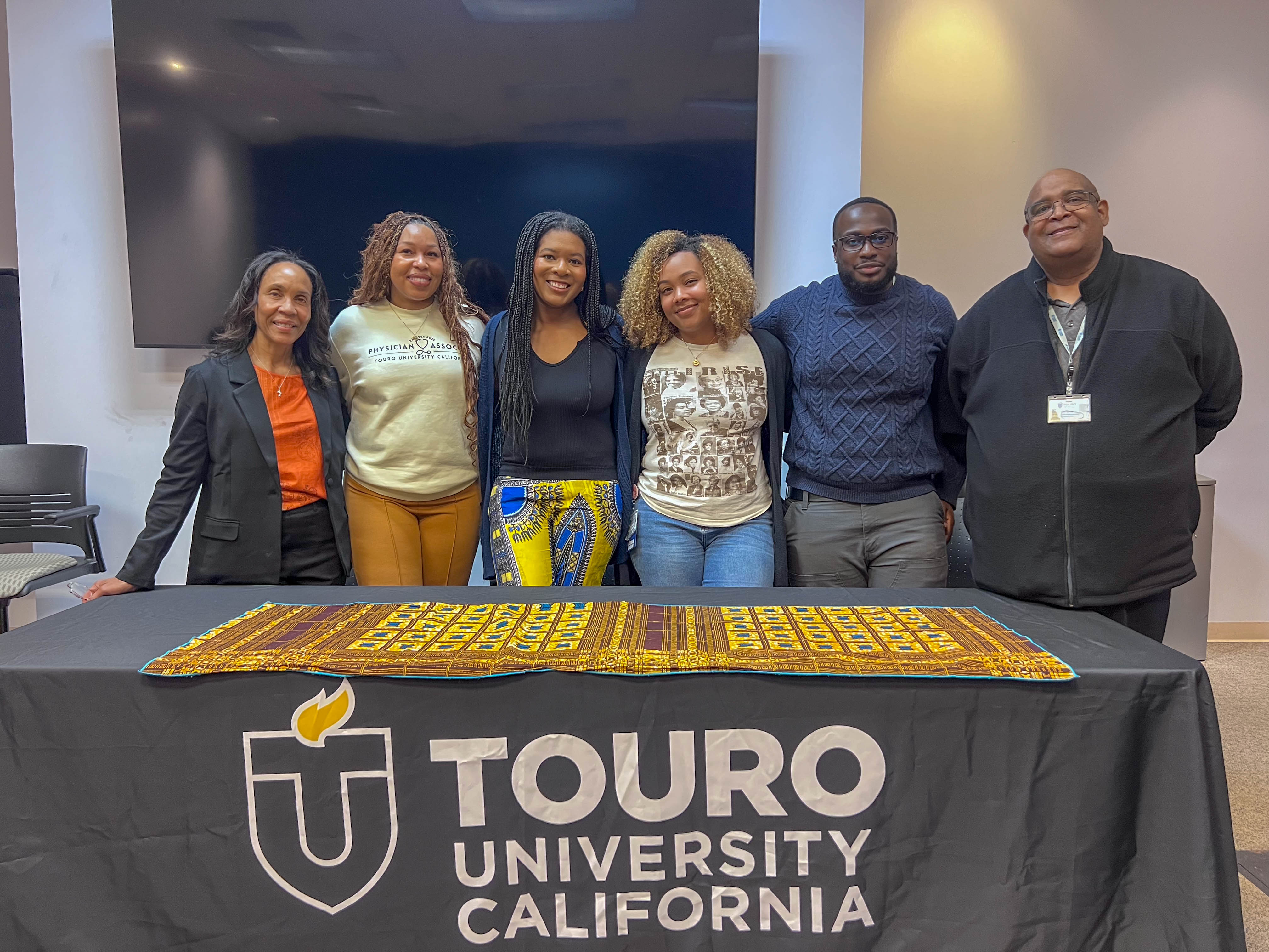 A photo shows Dr. Gayle Cummings, Director of the Public Health Program, Ranieja Matthews Ragster from the Joint MSPAS/MPH program, Beatrice Ojekunle from the Dual DO/MPH program, Destany Michael from the DO program, David Djan from the PharmD program, and Dr. Mark Gaines, Associate Director of Campus Engagement and Community Affairs after a Black History Month panel discussion on campus, Feb. 10, 2026.