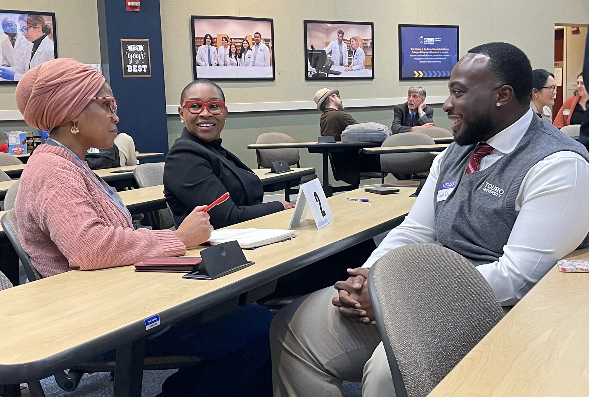 A photo shows College of Pharmacy alumnae Dr. Maya Yoder, PharmD 2015, and Dr. Brigitte Ouabo, PharmD 2016, as they mentor Student Pharmacist David Djan during the &ldquo;Back to Campus&rdquo; event on campus, Feb. 1, 2026.