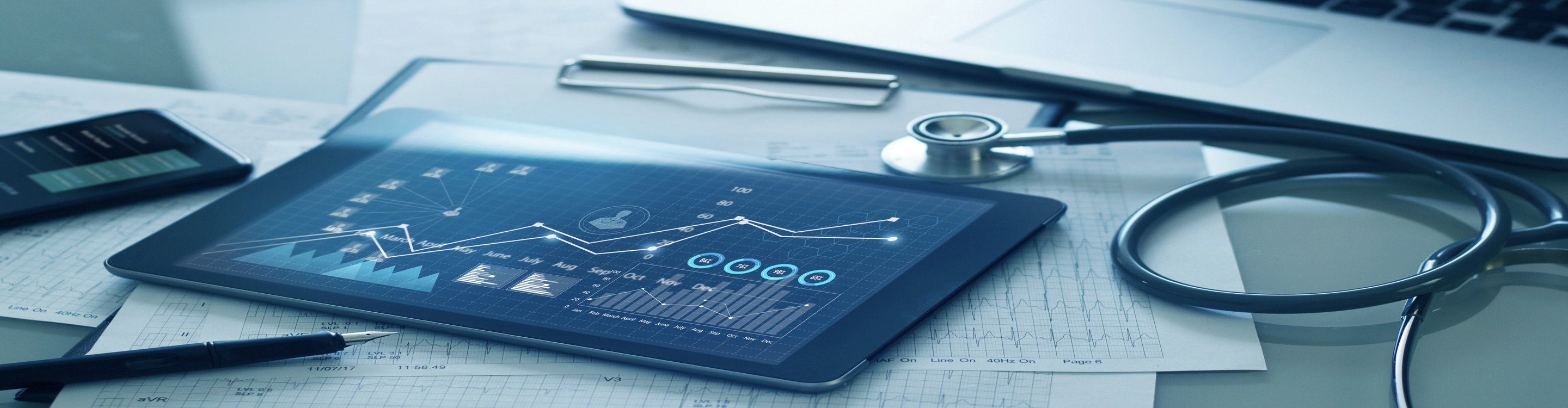 tablet, stethoscope and laptop on a desk