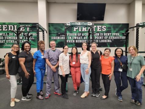 TUC School of Nursing faculty stand next to family nurse practitioner students inside Reedley High School gymnasium