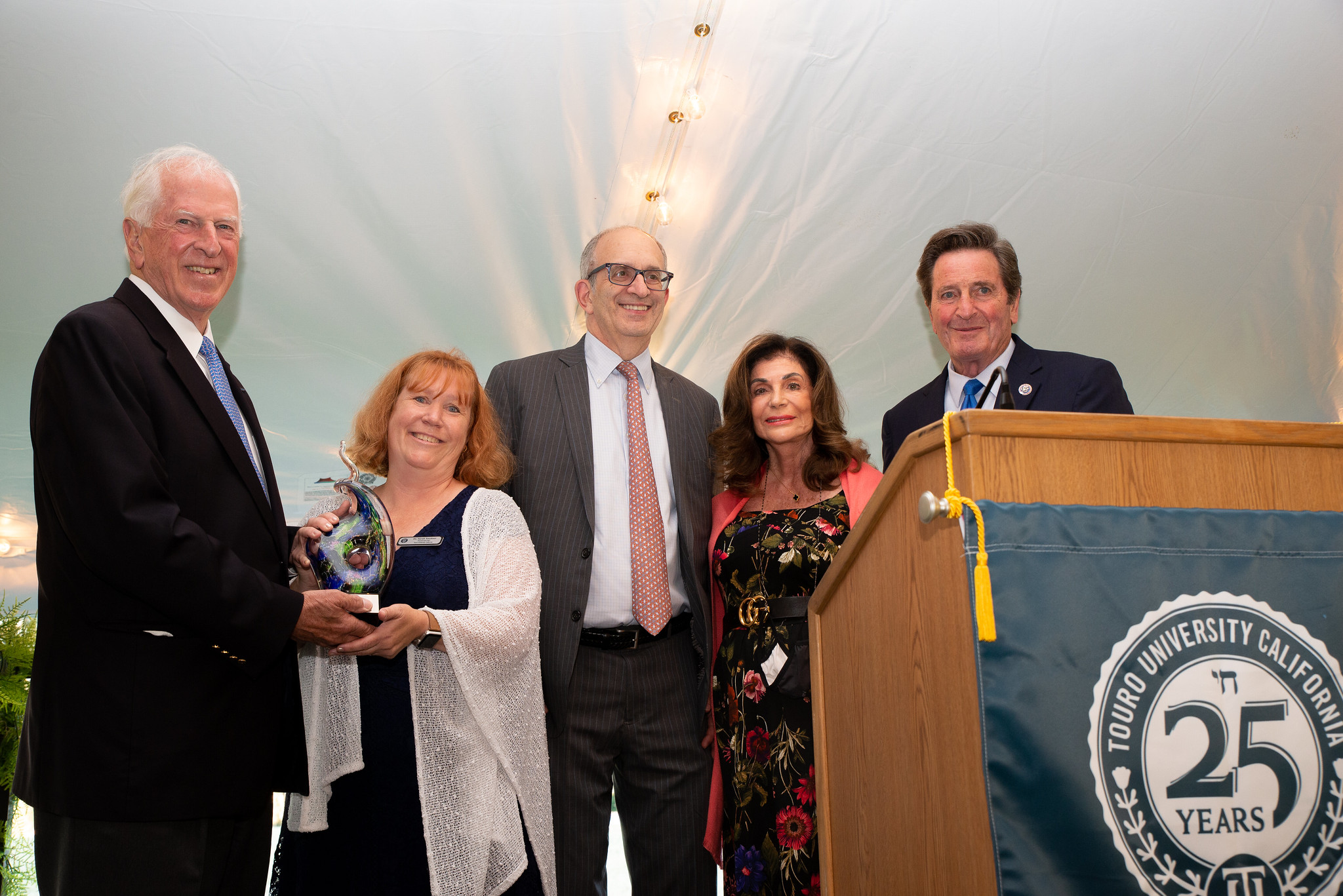 5 people on stage holding award for TUC\'s 25th Anniversary Gala.