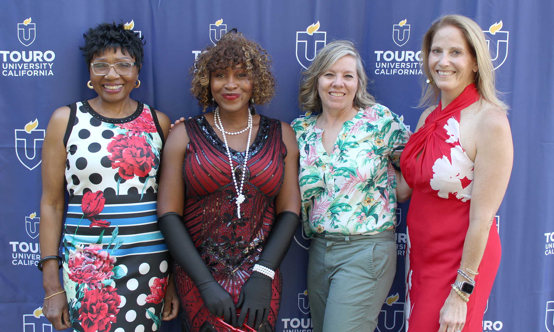 A photo shows Touro University California Alumni Association Board of Directors members, left to right, Treasurer Brenda Mitchell, Director Dr. Brigitte Ouabo, Vice President Maureen McGhee, and President Dr. Jennifer Himmel as they pose for a photo during the Mosaic Gala on campus, Aug. 22, 2024.