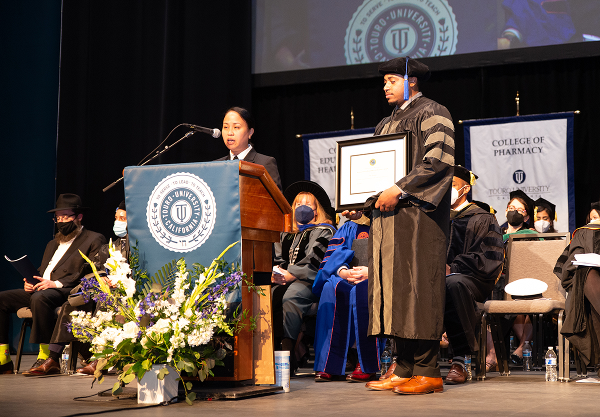 College of Pharmacy graduate Eric Flemings accepts an award from the United States Public Health Service during commencement in 2022.