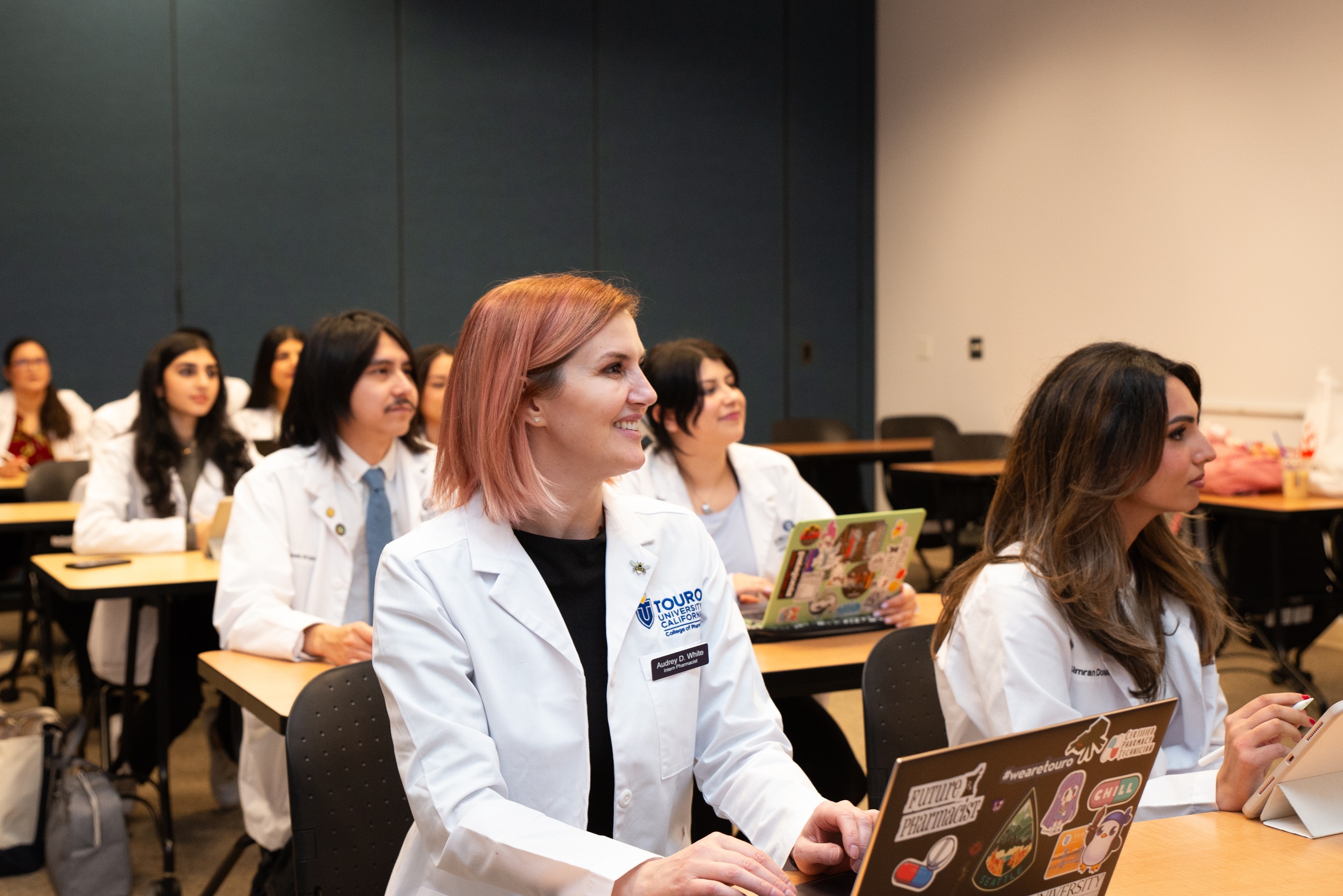 Students from the College of Pharmacy sit in class during lecture. 
