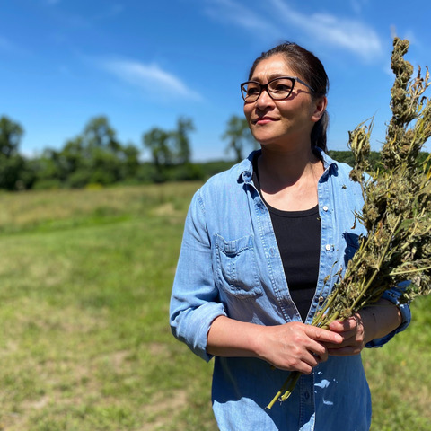 Alumnus June Chin in standing in a field