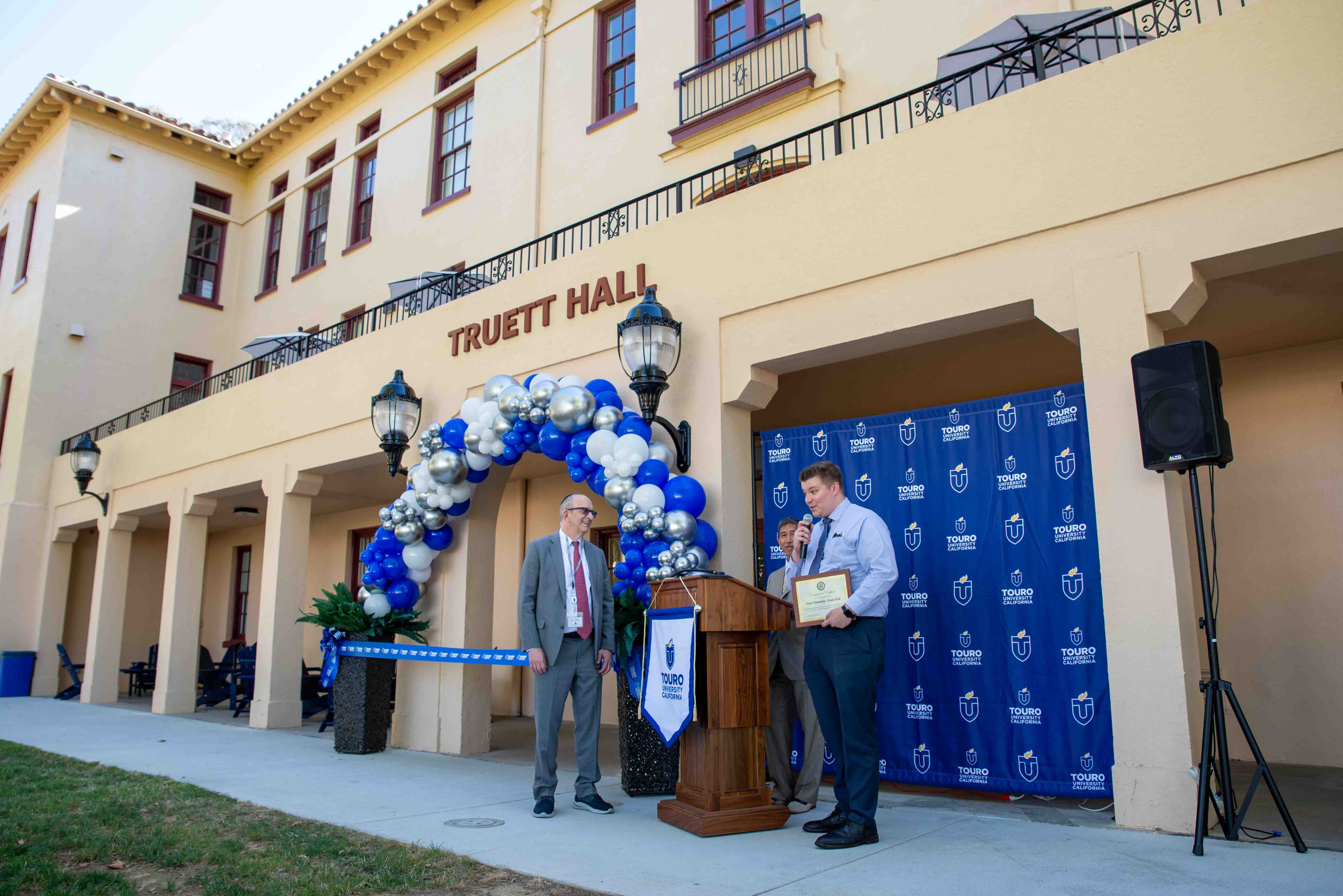 Touro President Alan Kadish accepts certificates during the ribbon cutting of Truett Hall.