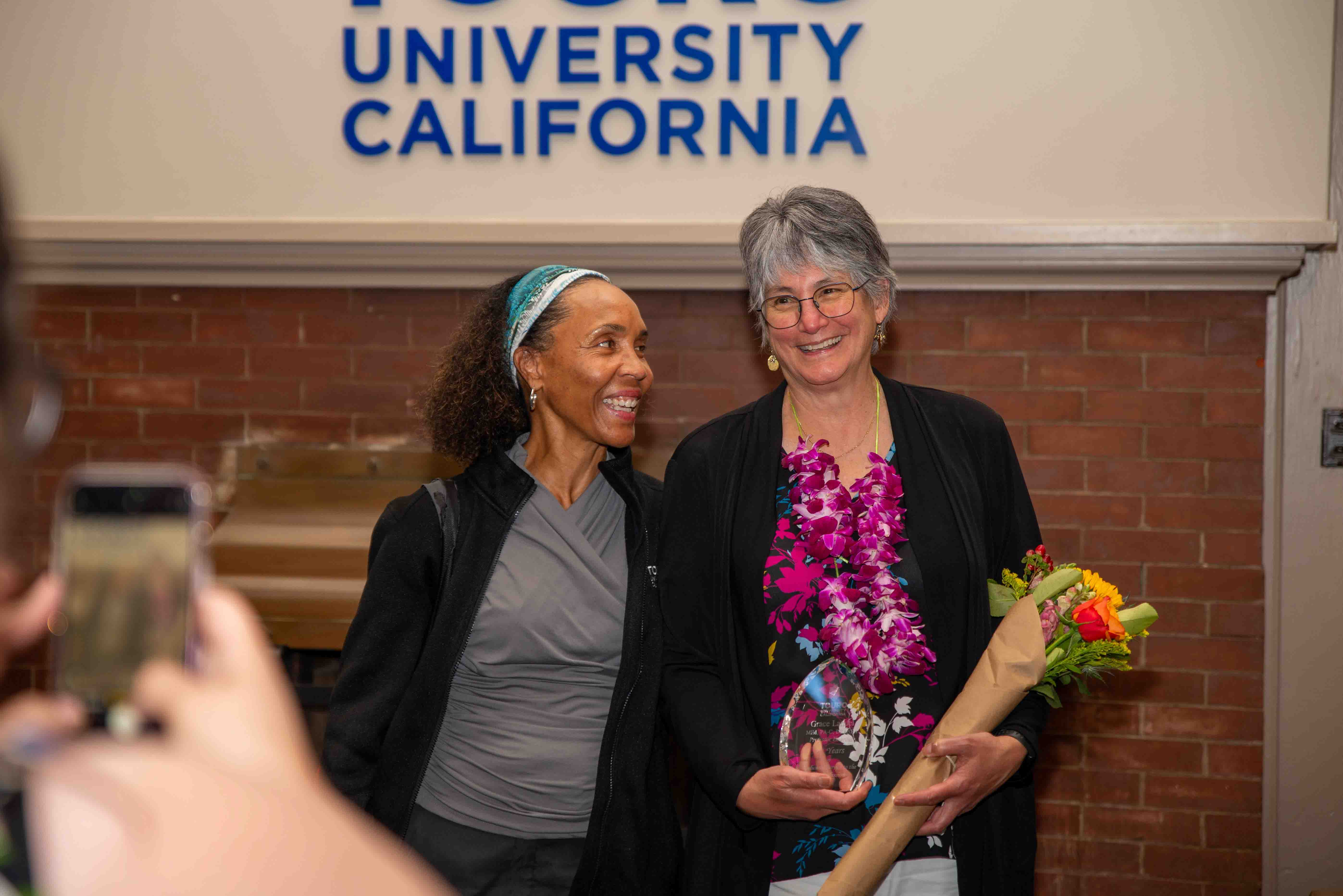 Dr. Gayle Cummings and Grace Landel exchange smiles during a farewell event in the Farragut Inn ballroom.