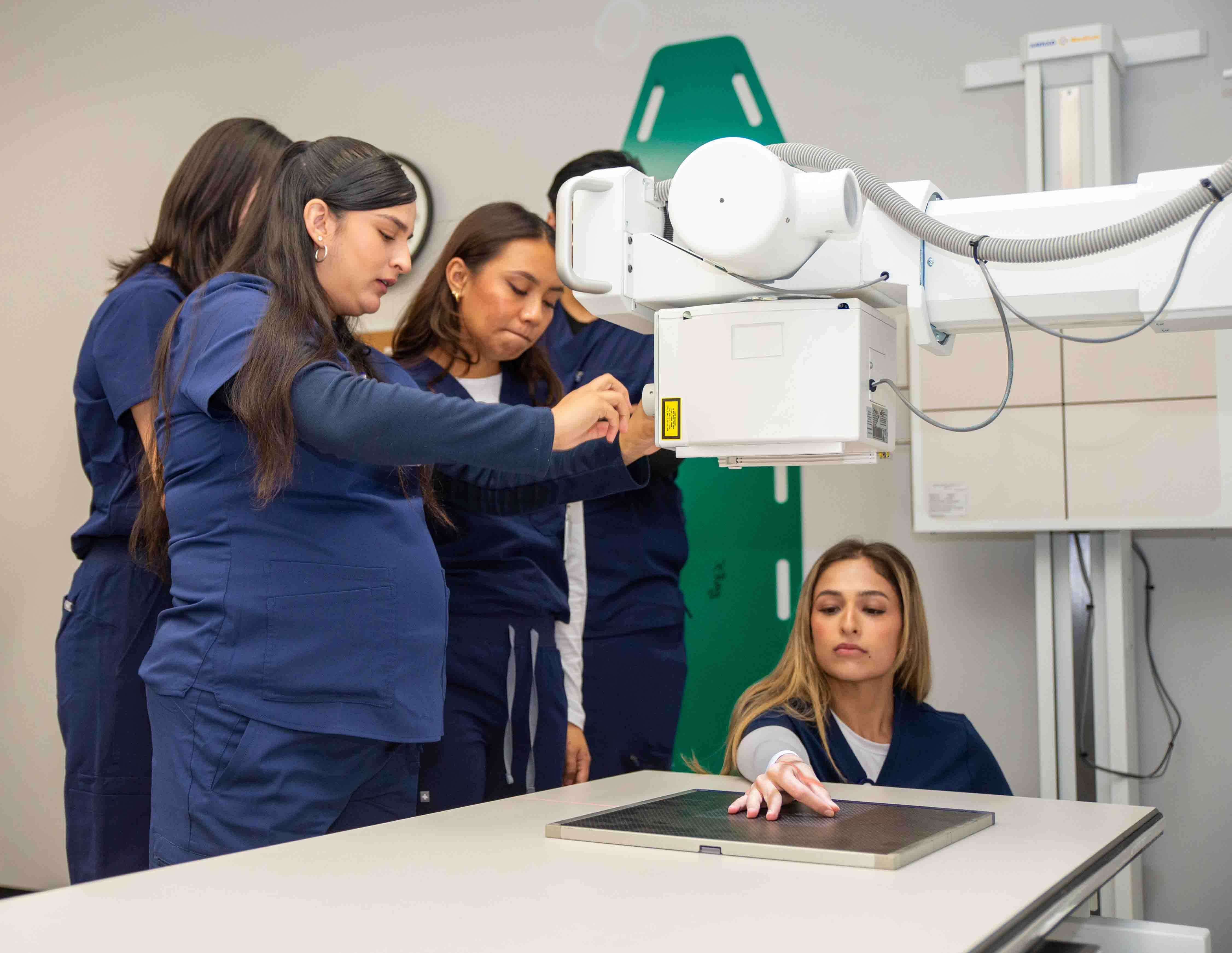 Radiology students practice prepping an x-ray machine during a classroom lab.