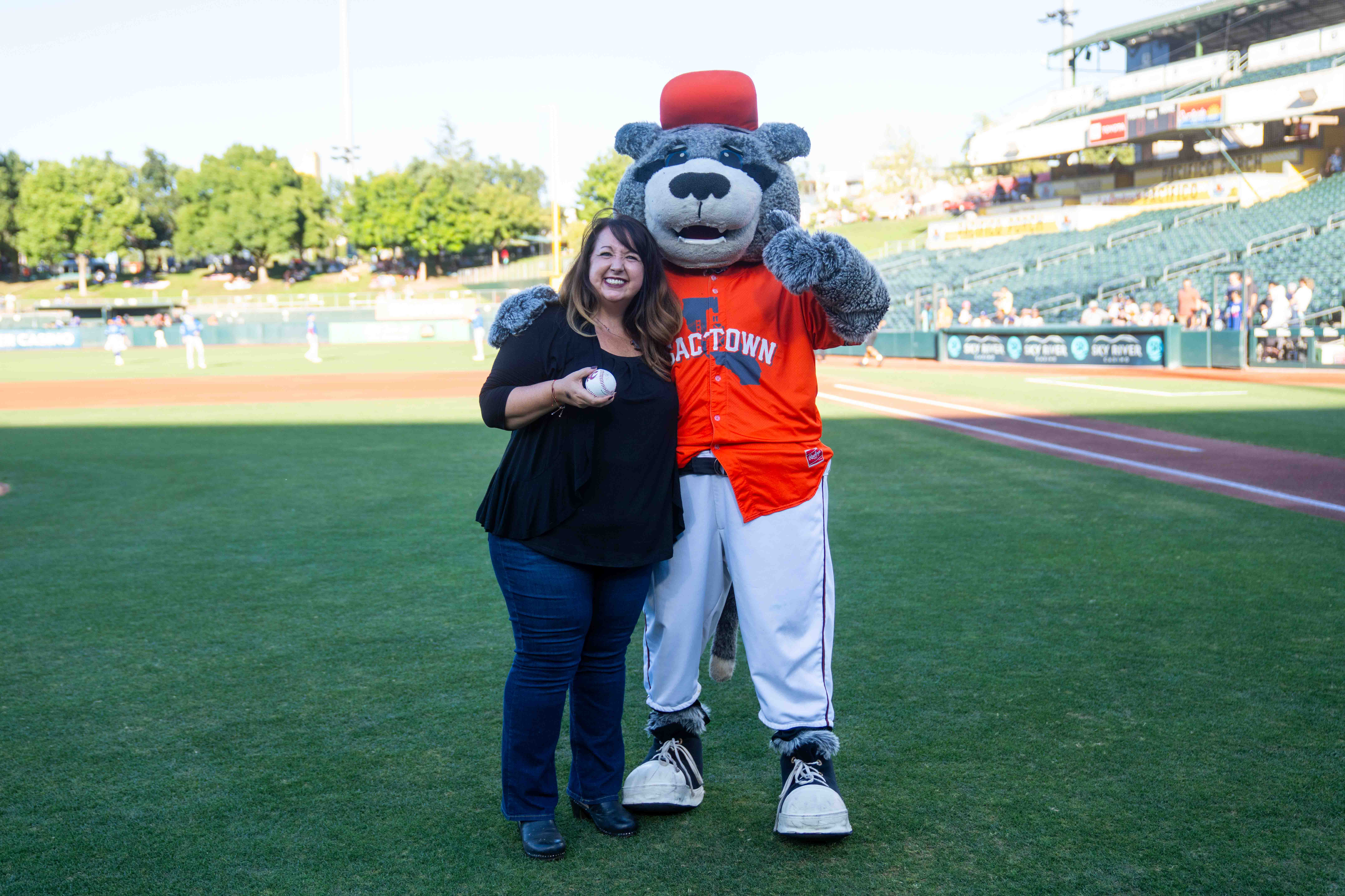 Dr. Tami Hendriksz with the Sacramento Rivercats mascot, Dinger, at Sutter Health Park.