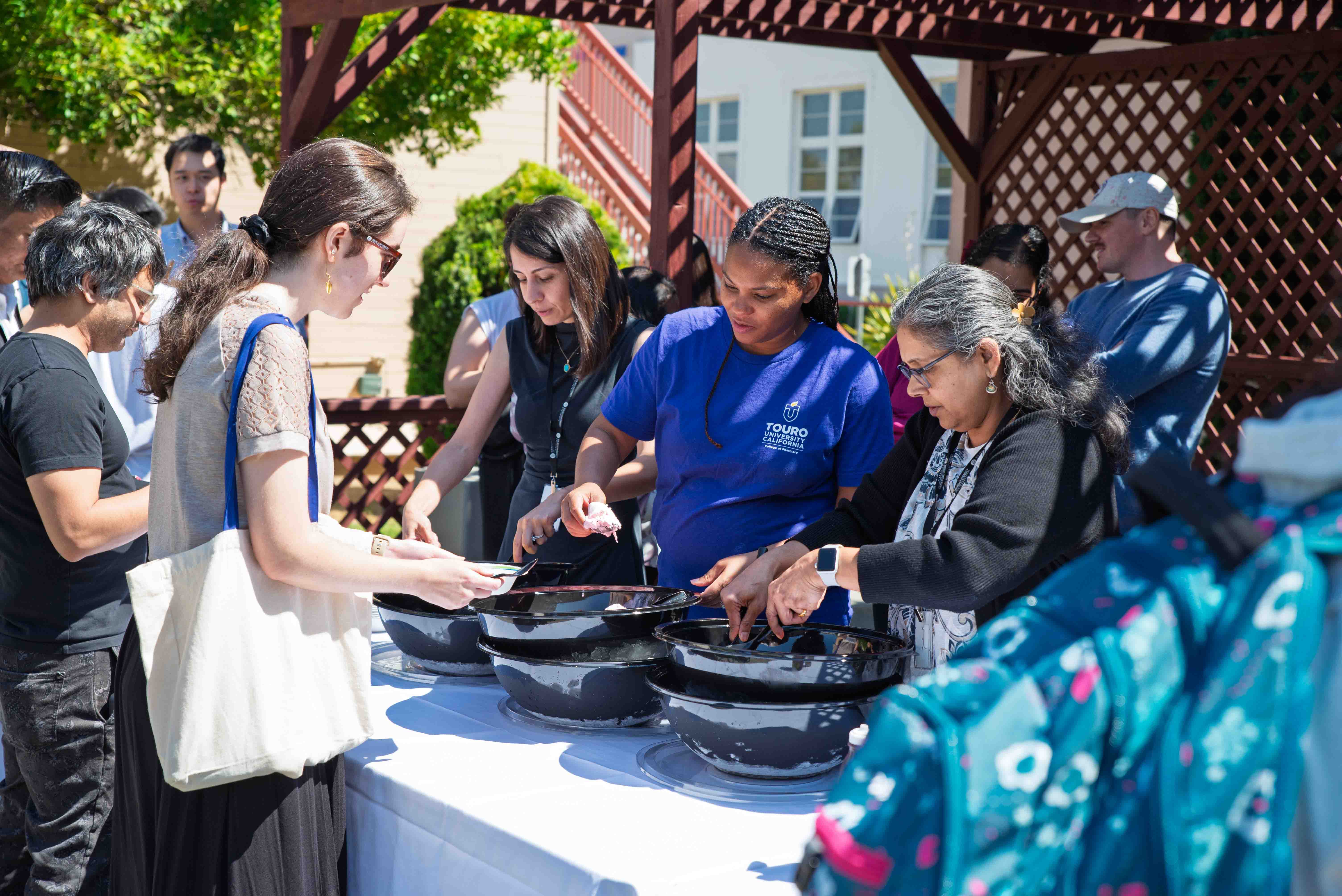 College of Pharmacy faculty serve ice cream to students as they rehearse their white coat ceremony.