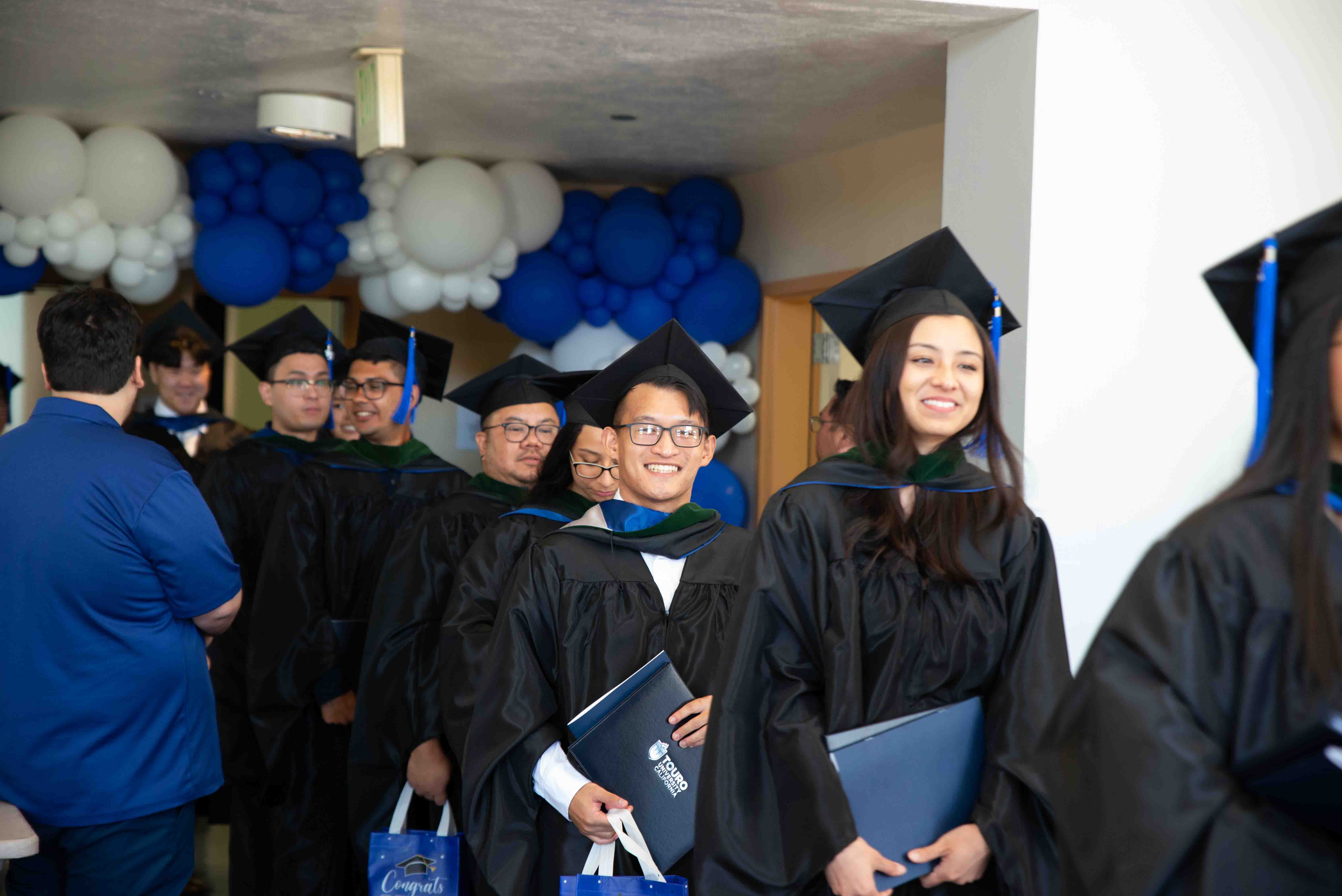 Students from Master of Science in Medical Health Sciences walk out of the Lander Hall auditorium after graduation.