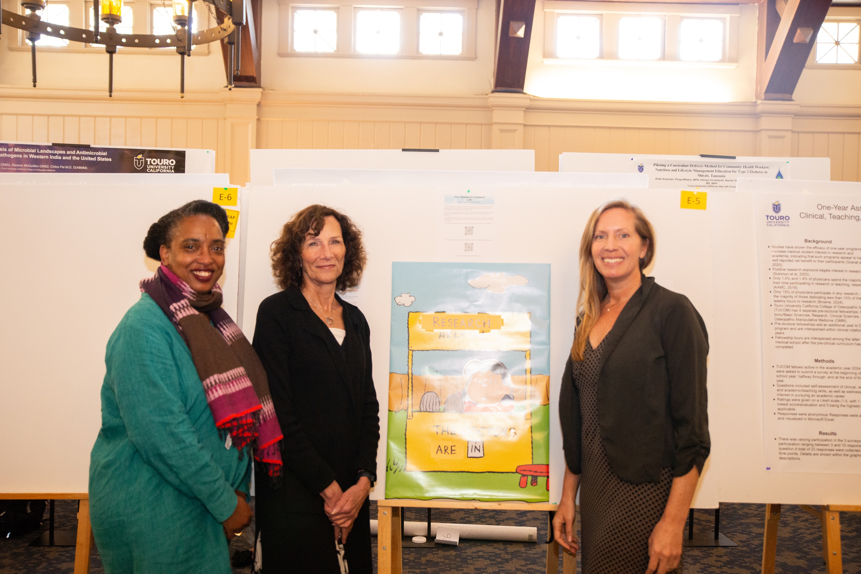 Dr. Carine Brody and faculty from the Public Health program during research day poster presentations..